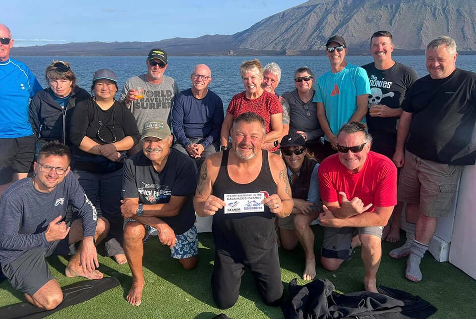 Group of dive friends smiling after a dive in the Galapagos Islands.